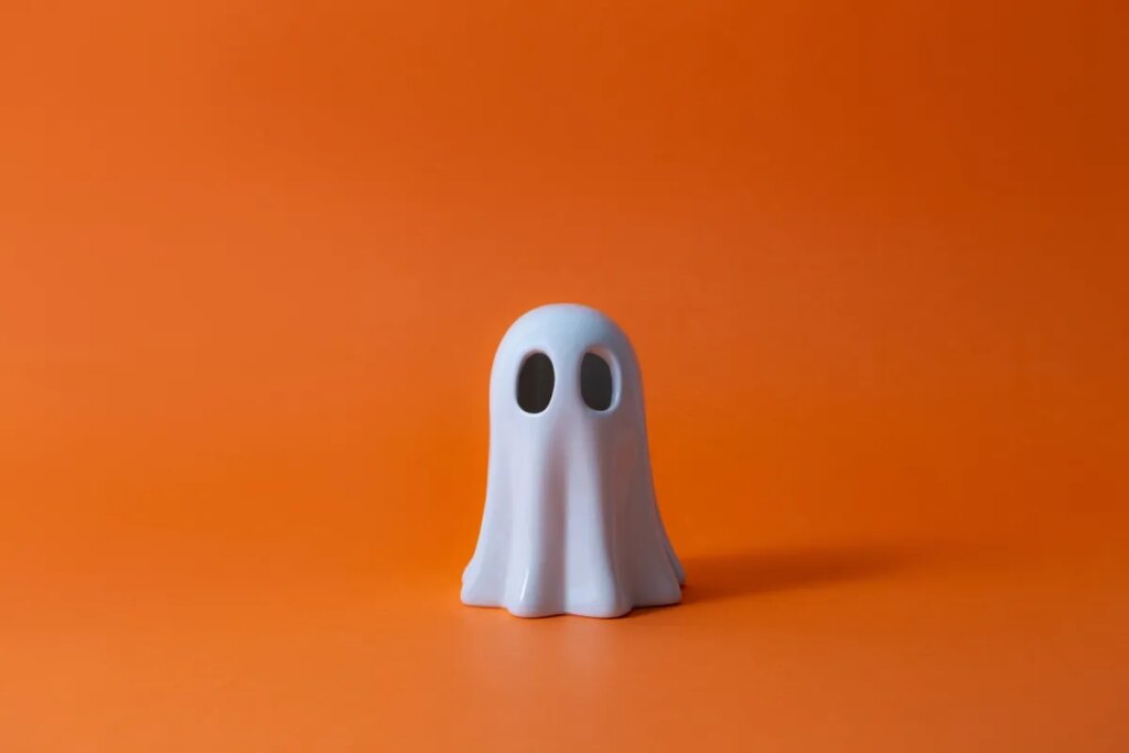 Cute Halloween Ghost over orange background.